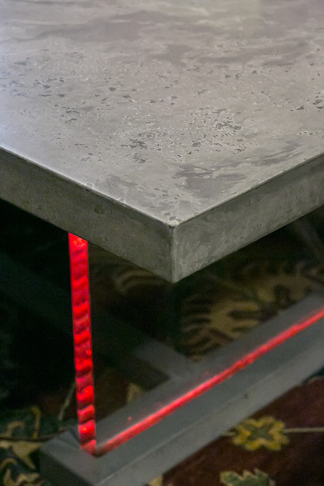 Close view of a concrete tabletop and illuminated steel base