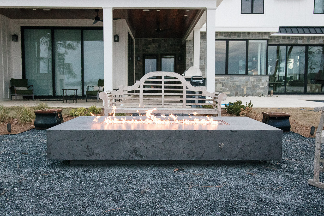 Large custom concrete firepit overlooking the water