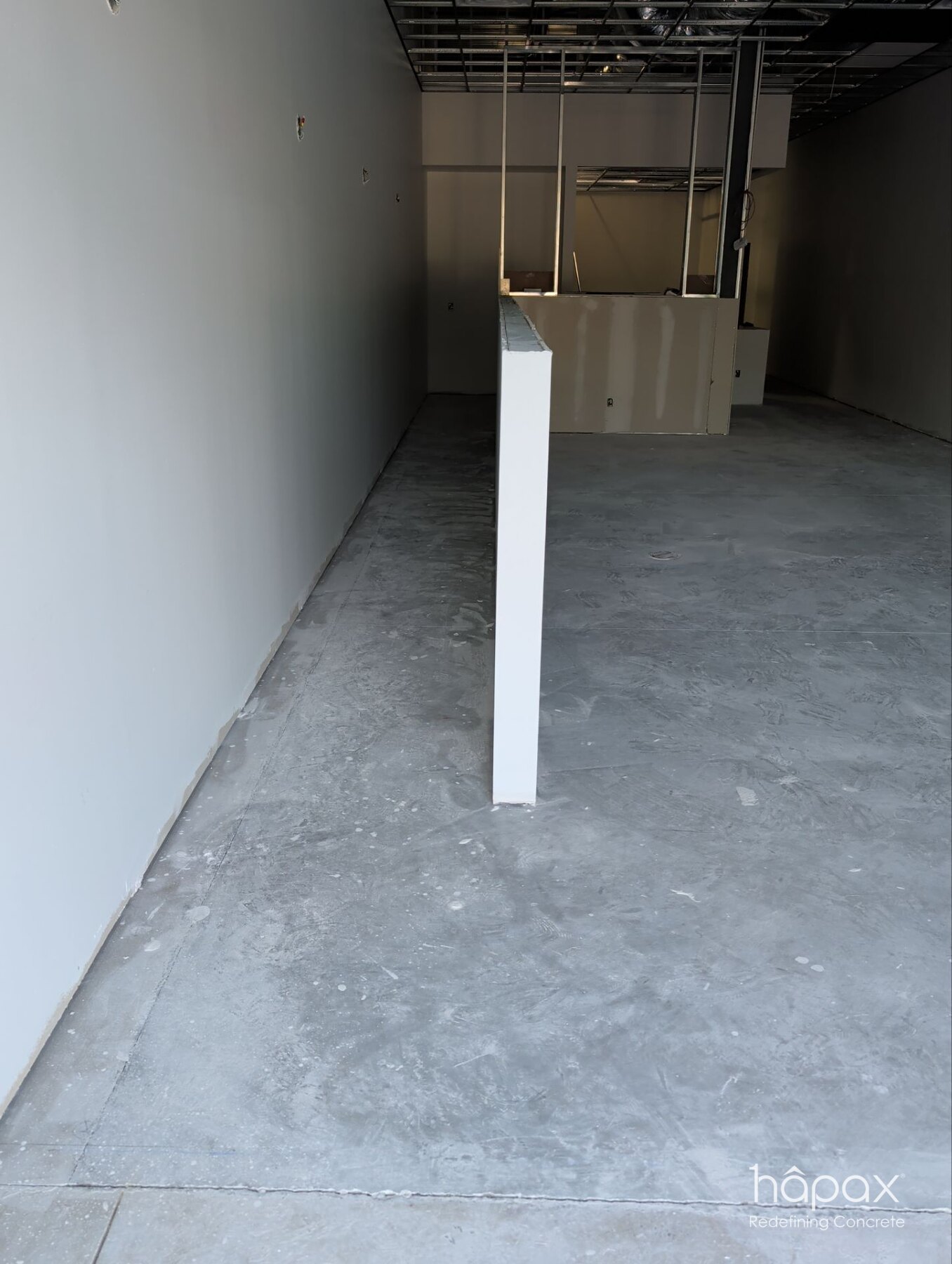 Unfinished concrete slab and partially built retail interior before polishing at Lolly’s Great Bridge.