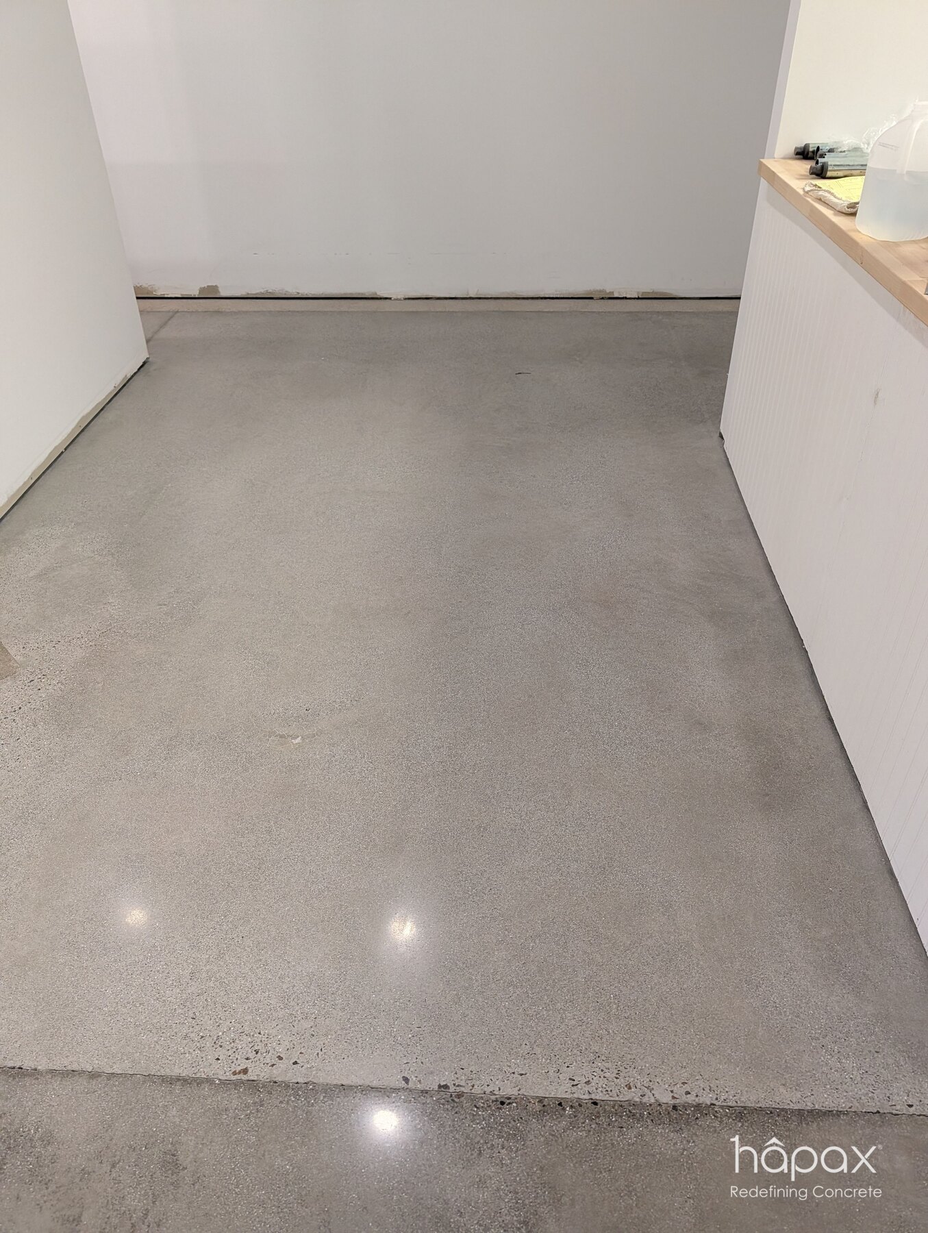 Close view of the refined polished concrete surface and light reflection in the Lolly’s retail space.